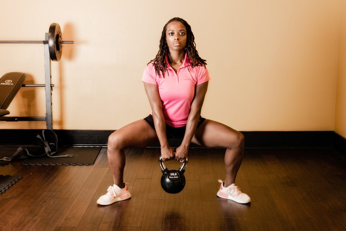 woman squatting with a kettlebell